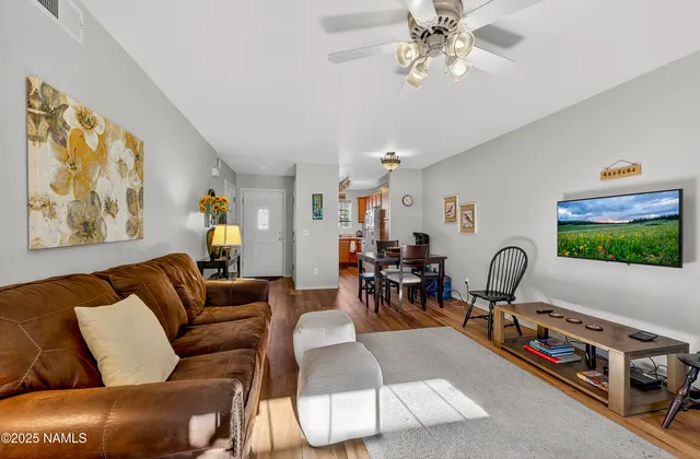 a living room with furniture a flat screen tv and a window
