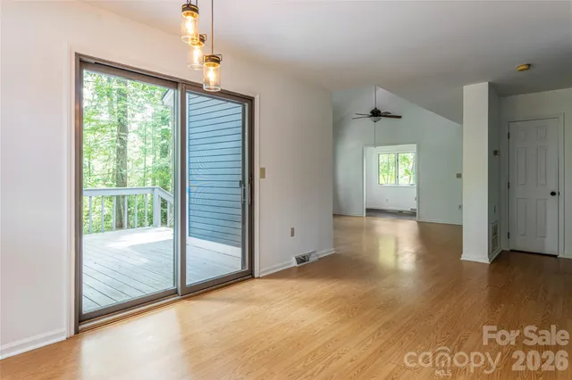 a view of an empty room with glass door and windows