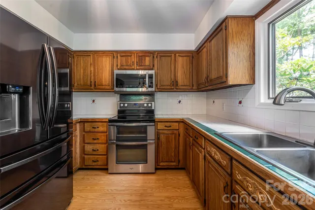 a kitchen with stainless steel appliances a stove sink microwave and cabinets