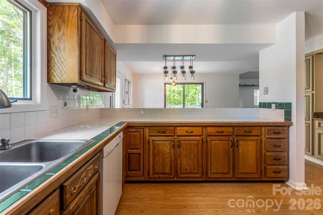 a kitchen with stainless steel appliances granite countertop a sink window and cabinets