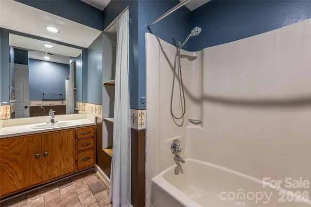 a bathroom with a tub sink and mirror