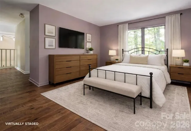 a spacious bedroom with a bed and a flat screen television