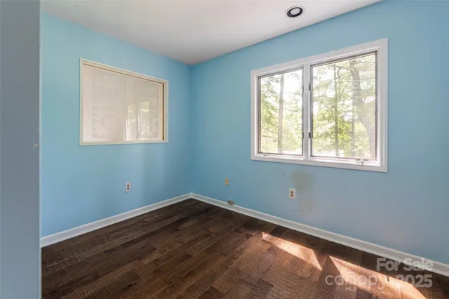 a view of a room with wooden floor and windows