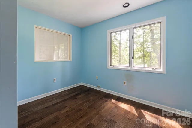a view of a room with wooden floor and windows