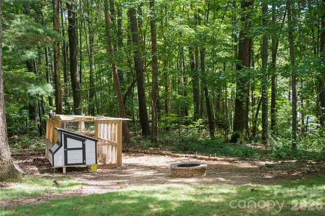 a view of a house with backyard and trees