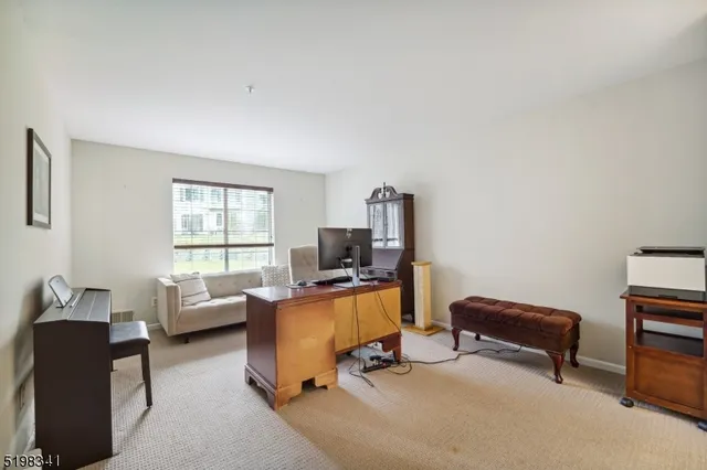 a view of a livingroom with workspace and a window