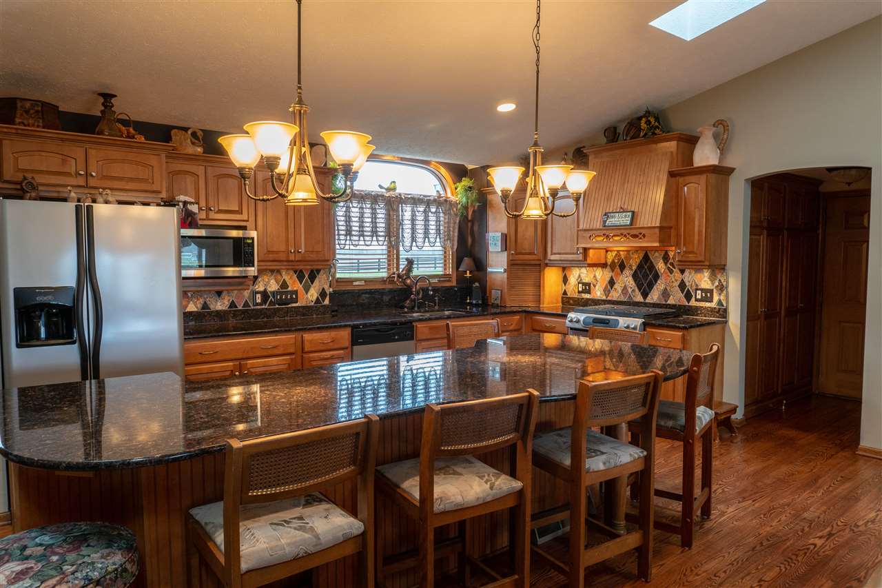 4545 River Road Cherry Valley, IL 61016 - Photo 3 of 25 a kitchen with stainless steel appliances granite countertop a dining table chairs and granite counter tops
