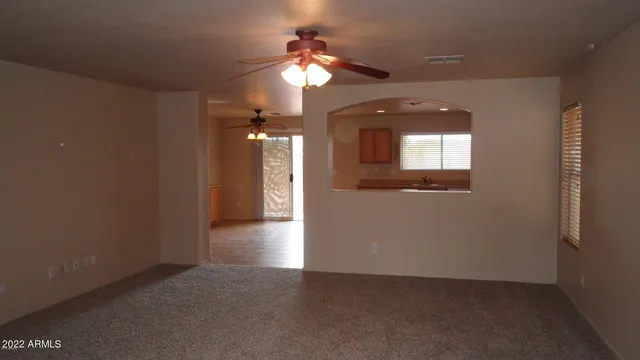 en view of a hallway with wooden floor and a kitchen