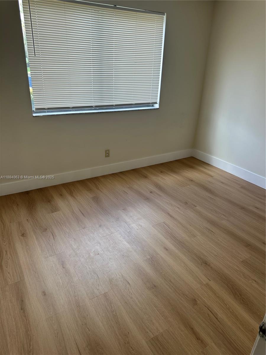 130 Northwest 60th Avenue, Unit 12 Margate, FL 33063 - Photo 11 of 16 an empty room with wooden floor