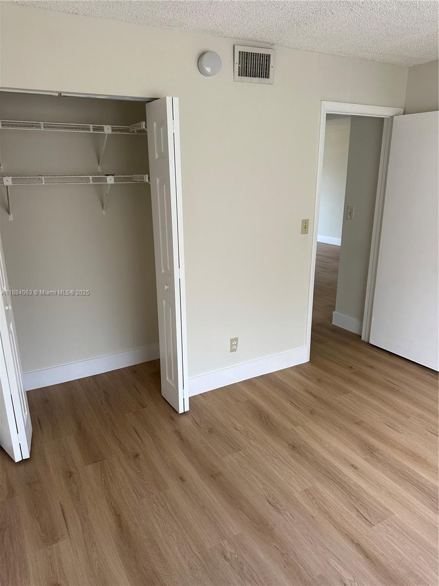 130 Northwest 60th Avenue, Unit 12 Margate, FL 33063 - Photo 7 of 16 an empty room with wooden floor and entrance