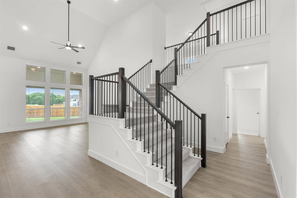 413 Tower Street DeSoto, TX 75115 - Photo 9 of 30 a view of staircase with wooden floor and fan