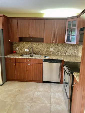 a kitchen with granite countertop a stove top oven sink and cabinets