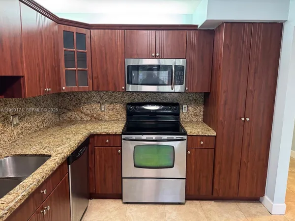 a kitchen with granite countertop wood cabinets and stainless steel appliances