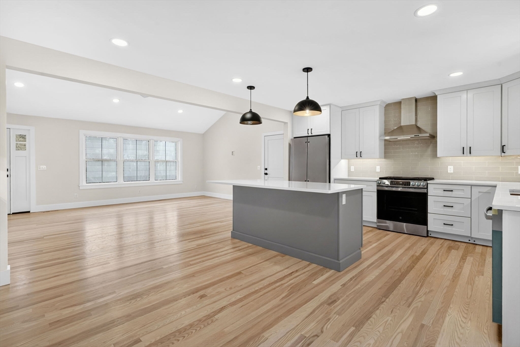 221 Cedar Swamp Road Monson, MA 01057 - Photo 14 of 37 a large kitchen with stainless steel appliances granite countertop a large counter top and a stove top oven with wooden floor