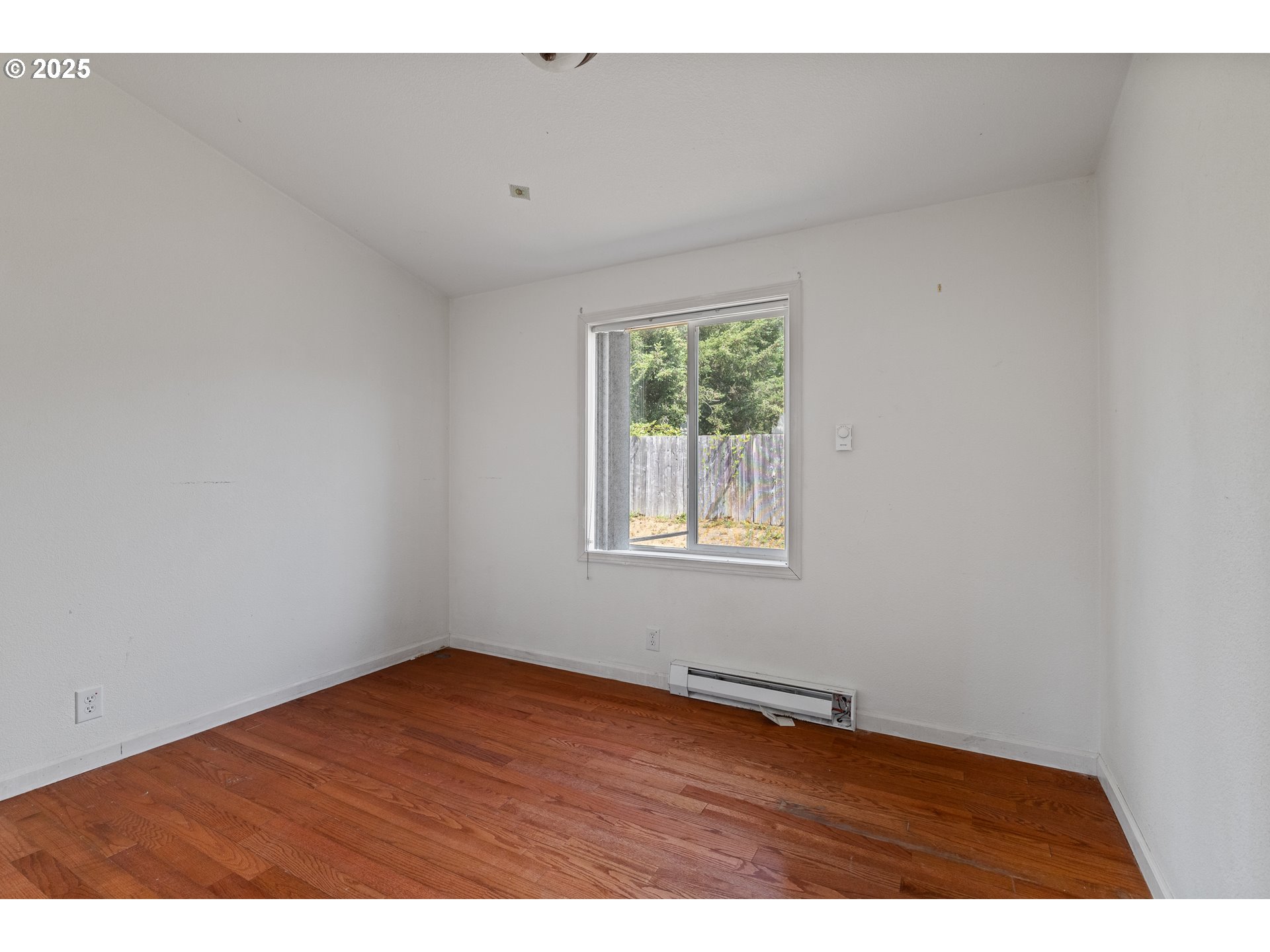 1829 East Willow Street Myrtle Point, OR 97458 - Photo 16 of 37 a view of an empty room with wooden floor and a window