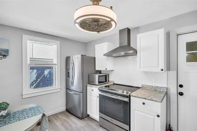 a kitchen with stainless steel appliances granite countertop a stove a refrigerator and a cabinets