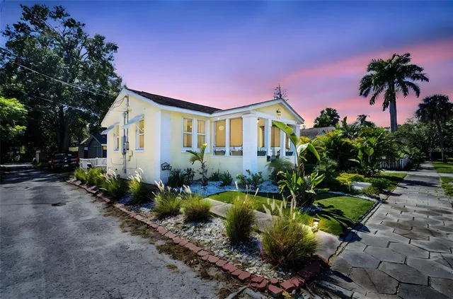 a front view of a house with a yard and potted plants