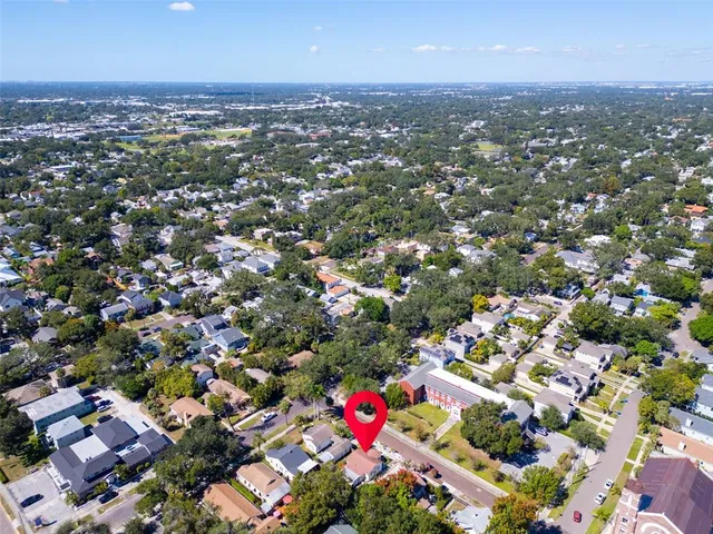 an aerial view of residential houses with outdoor space and trees