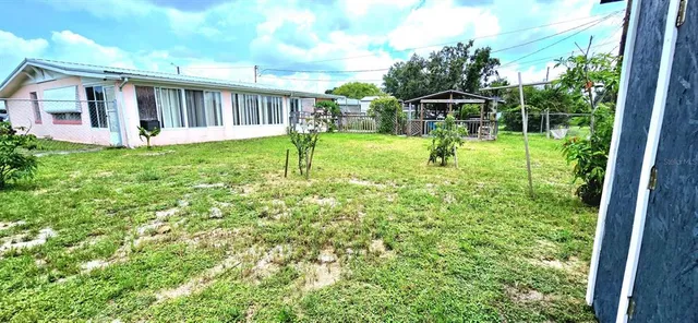 a view of house with backyard and a garden
