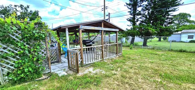 a view of a yard with wooden fence and trees