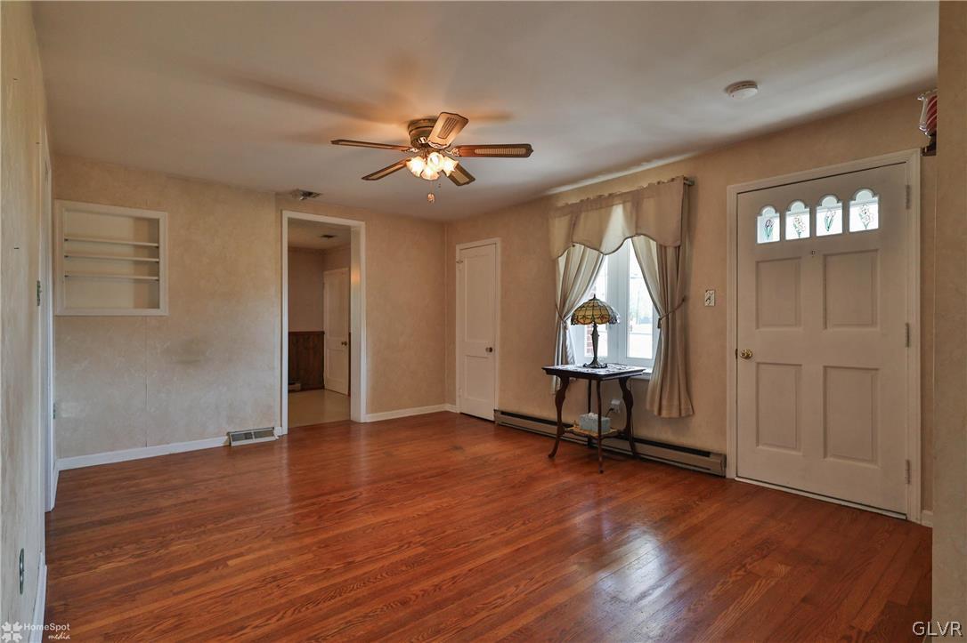 1215 Macada Road Bethlehem, PA 18017 - Photo 8 of 39 an empty room with wooden floor a ceiling fan and windows