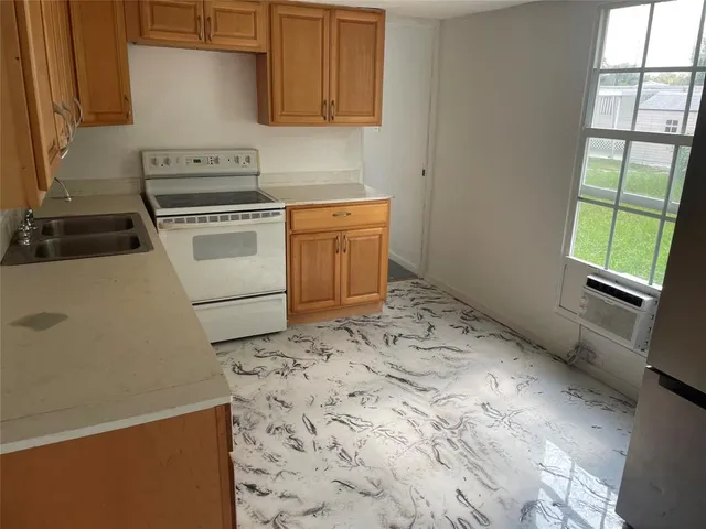 a kitchen with a stove a sink and a window