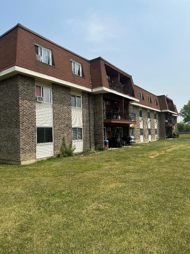 535 Hill Drive, Unit 201 Hoffman Estates, IL 60169 - Photo 2 of 2 a front view of a house with an outdoor space