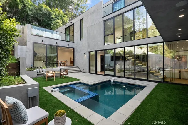 a view of pool with lawn chairs and couches