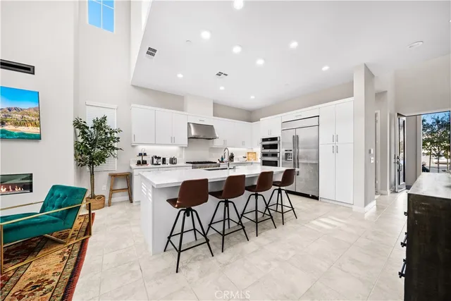 a kitchen with stainless steel appliances kitchen island granite countertop a table and chairs in it