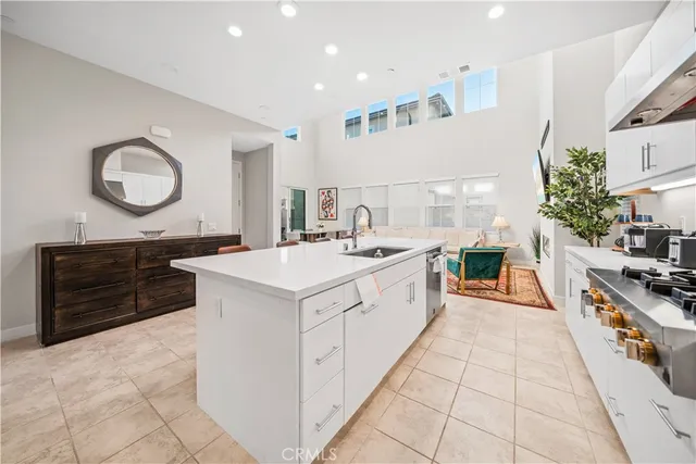 a large white kitchen with a stove a sink a refrigerator and a stove