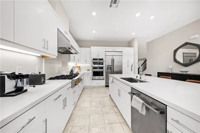 a large kitchen with stainless steel appliances kitchen island granite countertop a sink and cabinets