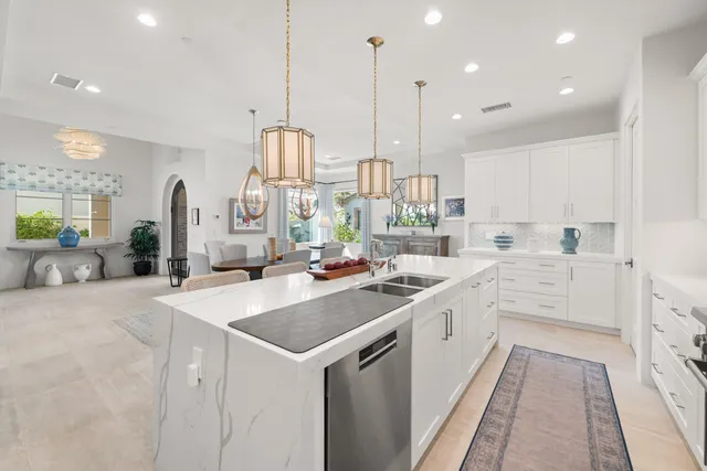 a kitchen with stainless steel appliances a sink and wooden floor