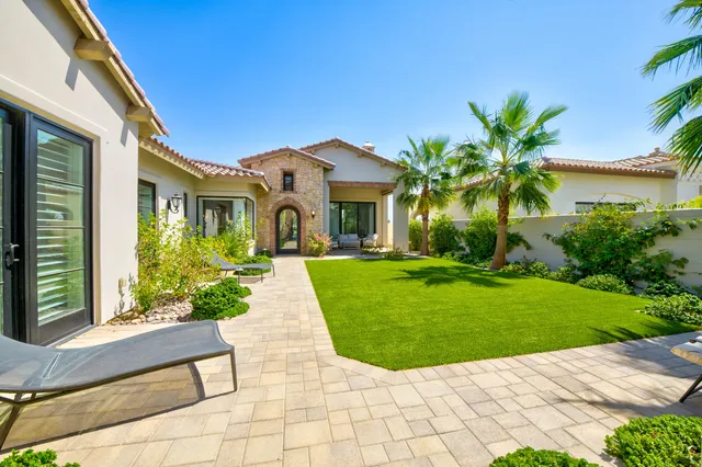 a front view of a house with a yard and potted plants