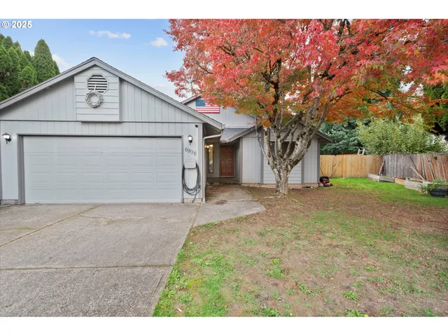a front view of house with garage and trees
