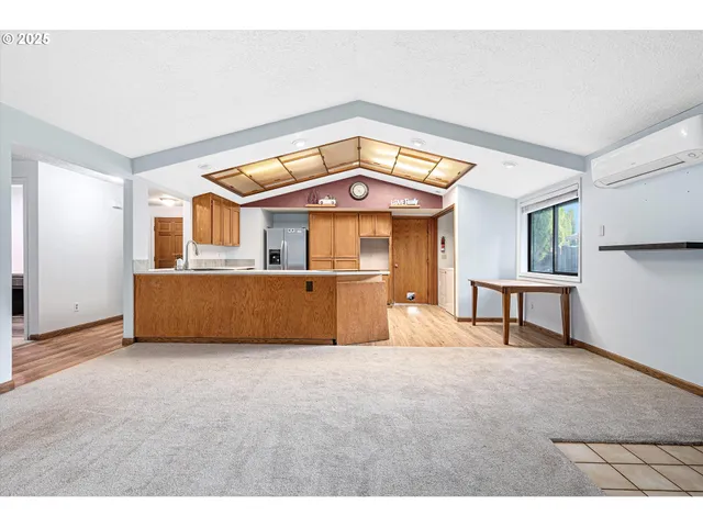 a view of a big room with wooden floor and a kitchen