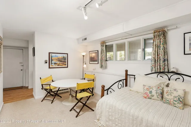 a bedroom with a bed a table and chair