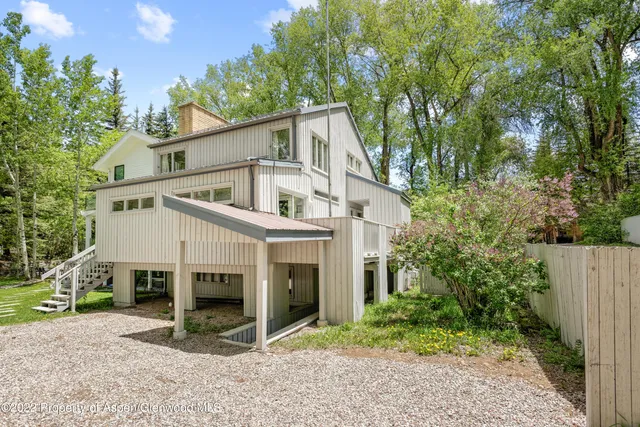 a white house that has a tree in front of it