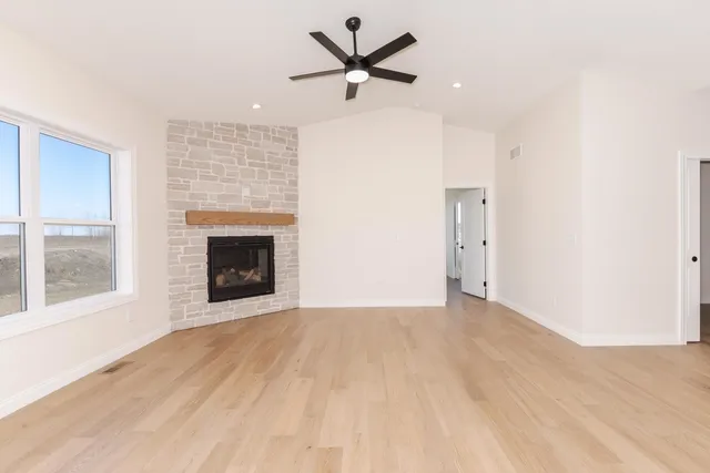 a view of an empty room with a fireplace and a window