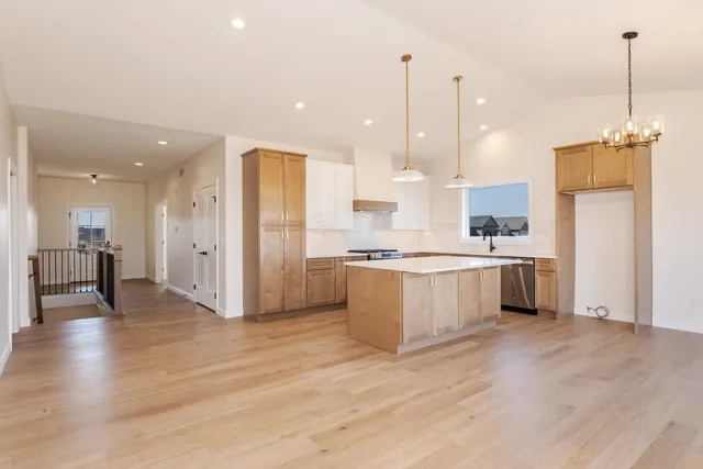 a kitchen with a sink a stove a refrigerator and white cabinets with wooden floor