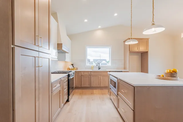 a kitchen with granite countertop a sink stove and refrigerator