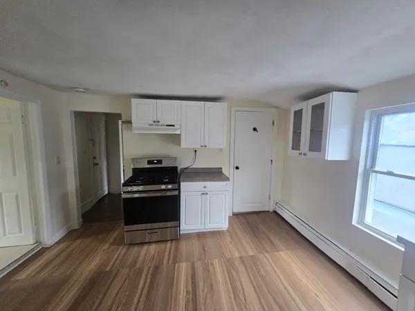 a kitchen with wooden floors and appliances