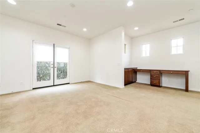 an empty room with windows and city view