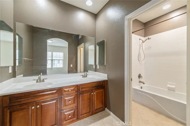 a bathroom with a double vanity sink and mirror with shower