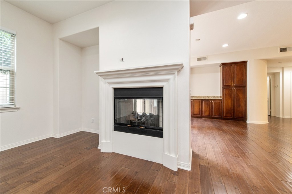 77 Hallmark Irvine, CA 92620 - Photo 8 of 35 a view of an empty room with wooden floor fireplace and a window