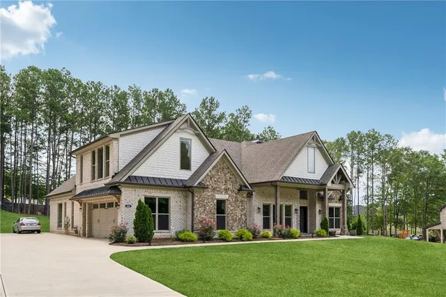 a view of a white house with a big yard and large trees