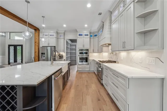 a large kitchen with stainless steel appliances granite countertop a lot of counter space and wooden floor