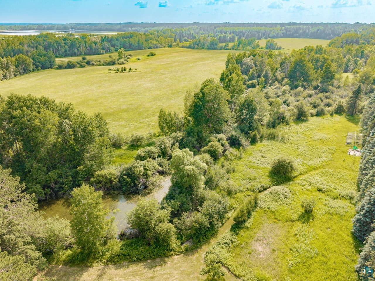4800 Tower Road Moose Lake, MN 55767 - Photo 36 of 83 Expansive natural landscape featuring lush greenery, mature trees, a tranquil winding stream, open grassy fields, and surrounding woodland