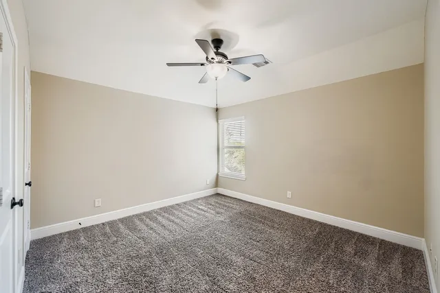 a view of a room with a ceiling fan and a window