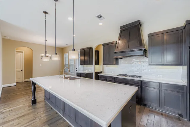a kitchen with kitchen island a sink appliances and cabinets