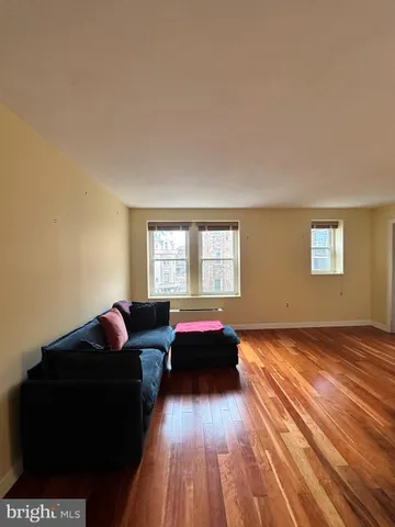 a living room with a bed furniture and a window